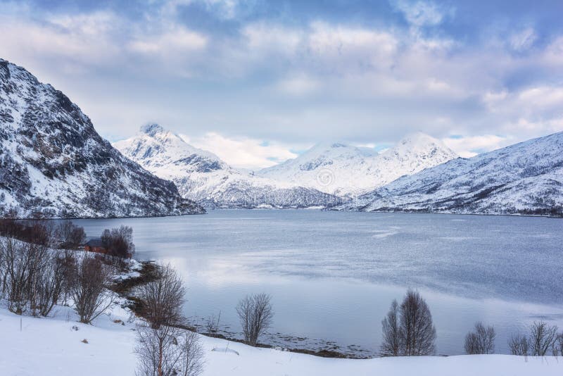 Beautiful winter daytime landscape with lake, snowy mountains and blue cloudy sky stock image Beautiful winter daytime landscape with lake, snowy mountains and blue cloudy sky stock image