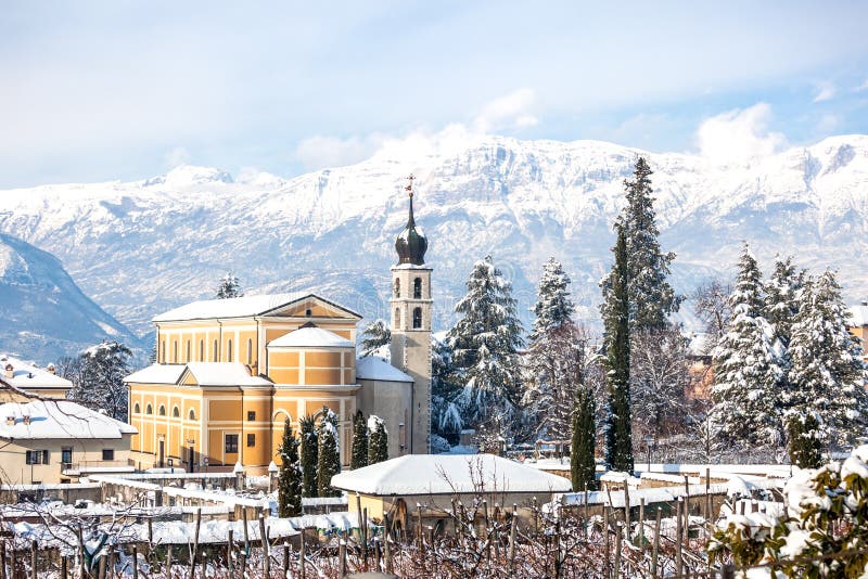 Beautiful winter landscape with church and Alps in Trento