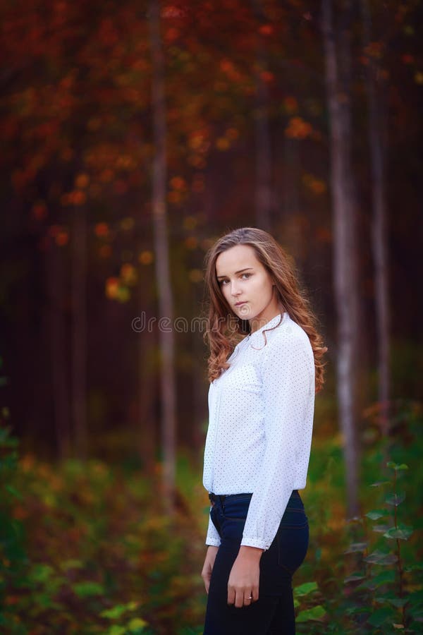 Beautiful woman in the autumn forest. Young brunette girl