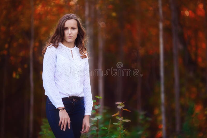 Beautiful woman in the autumn forest. Young brunette girl