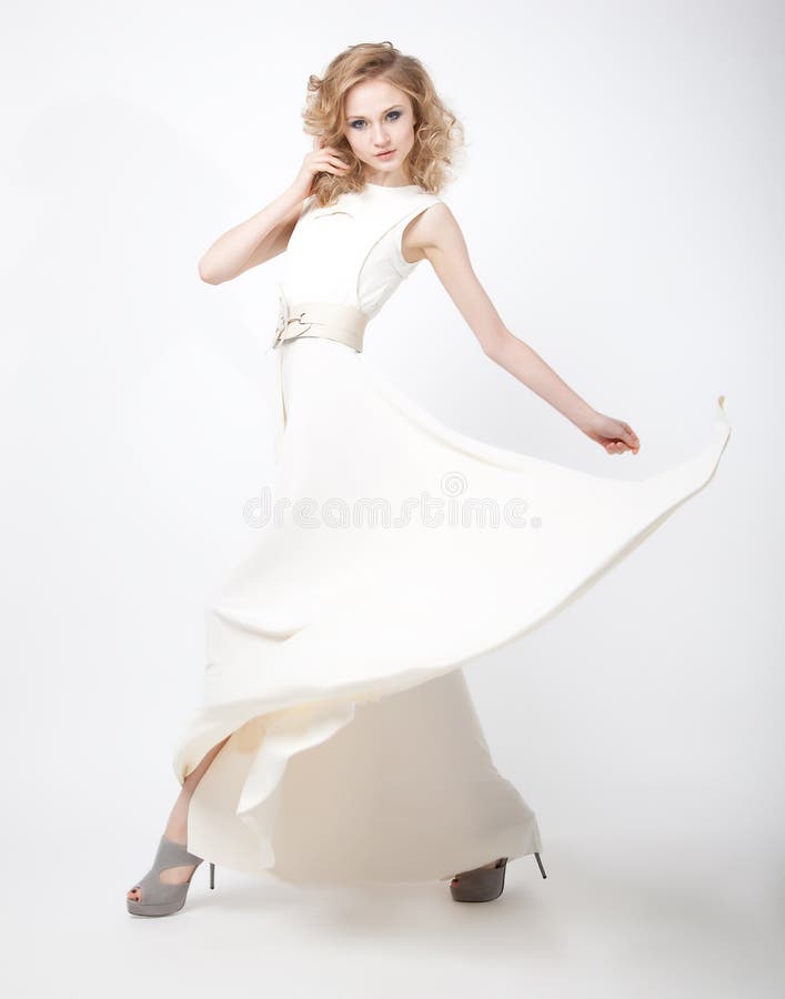 Beautiful woman blonde in flying vernal white dres