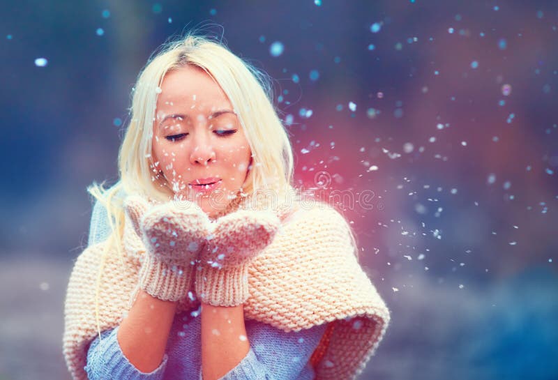 Beautiful Woman Blowing Winter Snow From Knitted Mittens Stock Image