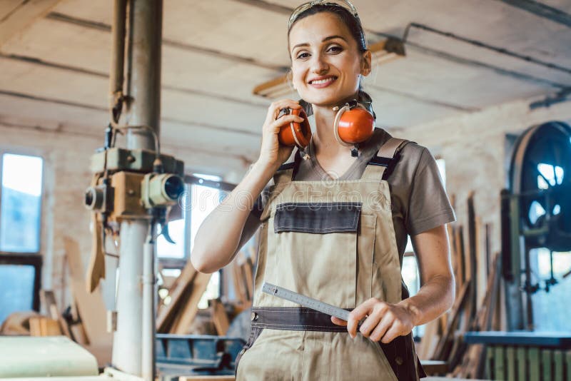 Beautiful woman carpenter in her woodwork workshop royalty free stock image