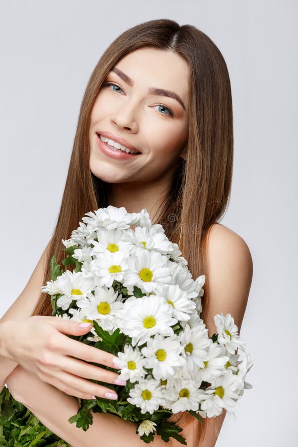 Beautiful Woman with Clean Fresh Skin holding flowers royalty free stock photography Beautiful Woman with Clean Fresh Skin holding flowers royalty free stock photography