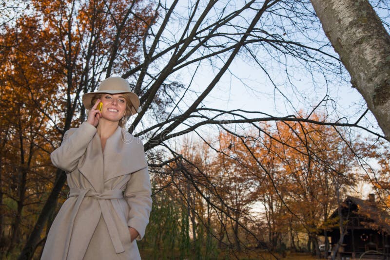 Beautiful woman in a coat hat and a white dress for a walk in an autumn park or forest. royalty free stock images Beautiful woman in a coat hat and a white dress for a walk in an autumn park or forest. royalty free stock images