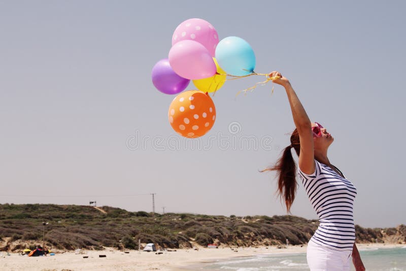 Beautiful woman with colorful balloons. On seaside stock photo Beautiful woman with colorful balloons. On seaside stock photo