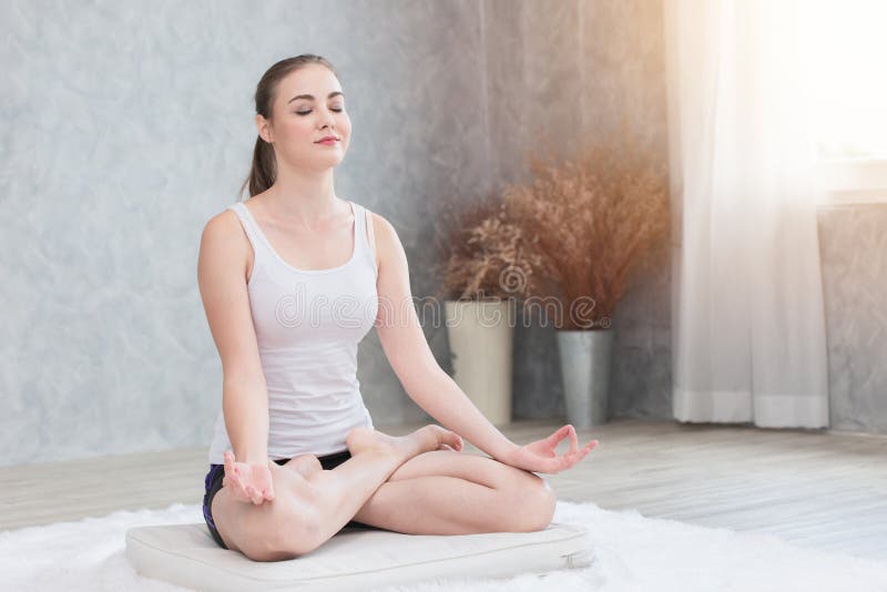 Beautiful woman do Yoga sitting concentration peaceful calm smile