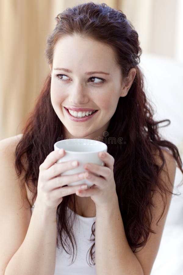 Beautiful woman drinking a cup of coffee in bed stock photos