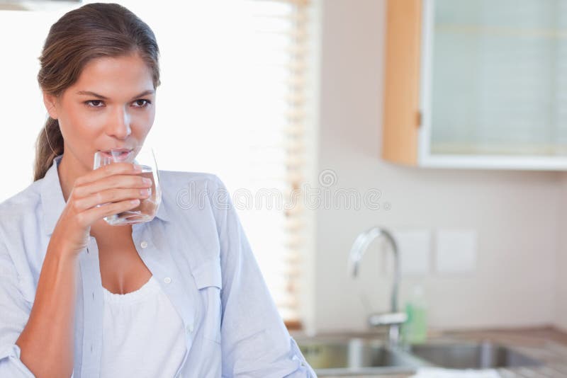 Beautiful woman drinking a glass of water royalty free stock photos