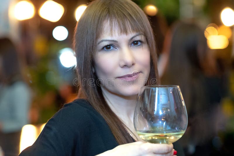 Portrait beautiful woman having fun in a bar drinking wine on blurred lights festive background. royalty free stock photos Portrait beautiful woman having fun in a bar drinking wine on blurred lights festive background. royalty free stock photos