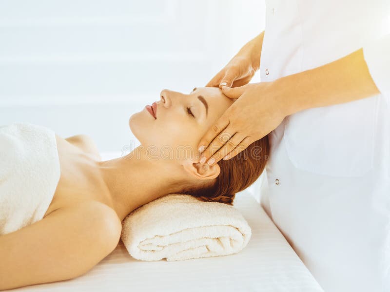 Beautiful Woman Enjoying Facial Massage With Closed Eyes In Sunny Spa Center Relaxing Treatment