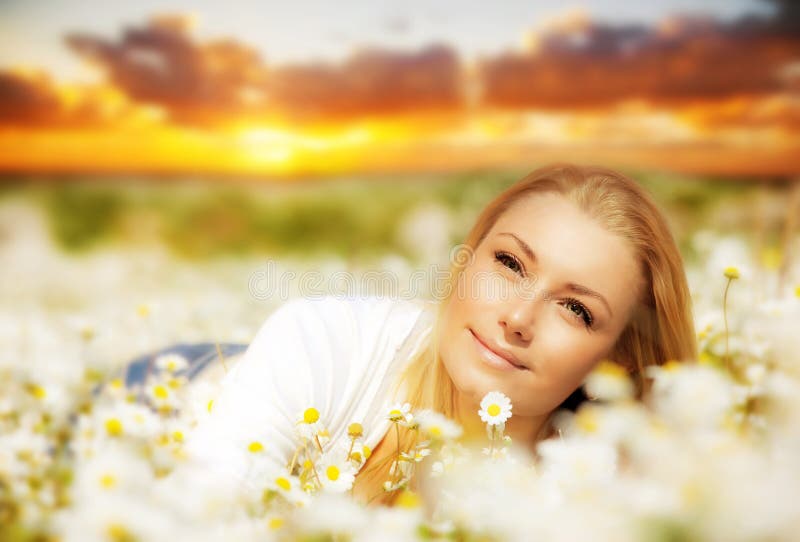 Beautiful woman enjoying flower field on sunset