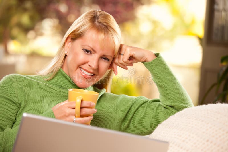 Beautiful Woman Enjoys Her Warm Drink and Laptop