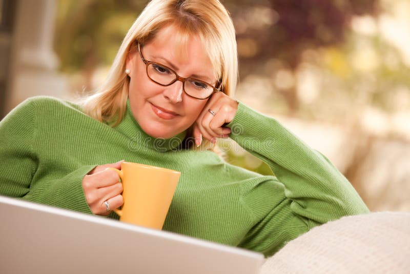 Beautiful Woman Enjoys Her Warm Drink and Laptop