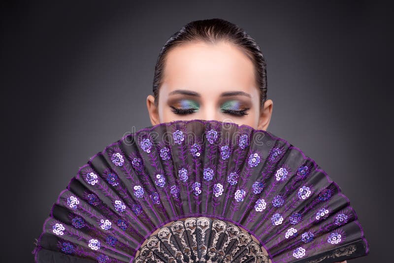 The beautiful woman with fan in fashion concept