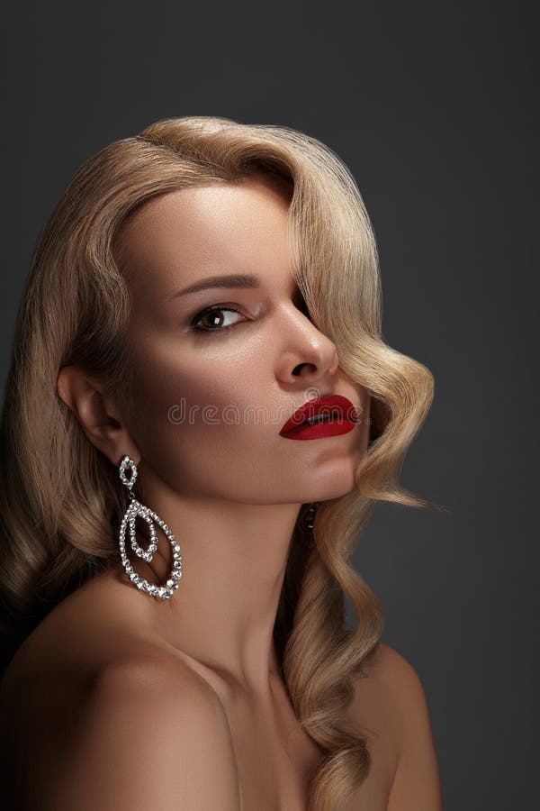 Beautiful Woman with Fashion Make-up and Blond Wave Hairstyle. Glamour American Diva Style with Brilliant Accessories