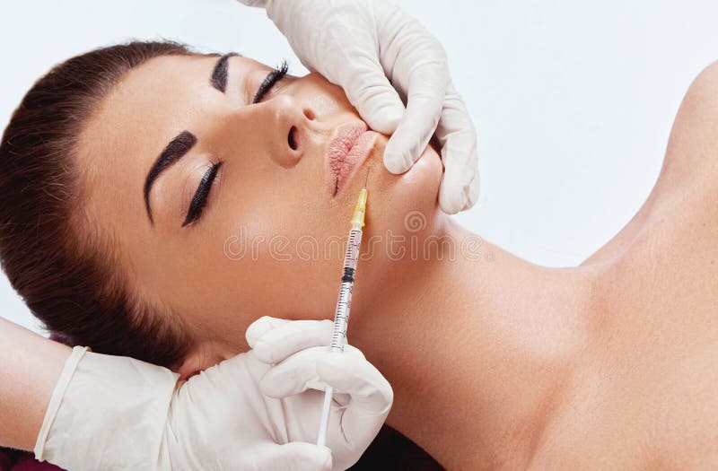 Beautiful woman getting cosmetic injection in lips, Plastic surgery, beauty concept. stock photo Beautiful woman getting cosmetic injection in lips, Plastic surgery, beauty concept. stock photo