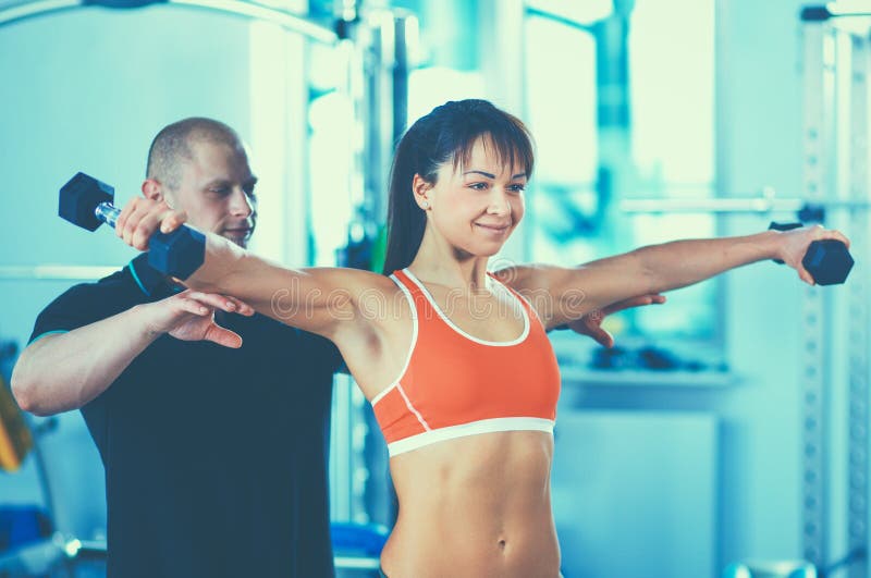 Beautiful Woman At The Gym Exercising With Her Trainer Stock Image Image Of Trainer Exercise