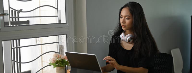 A beautiful woman with a headphone is using a computer tablet. stock images