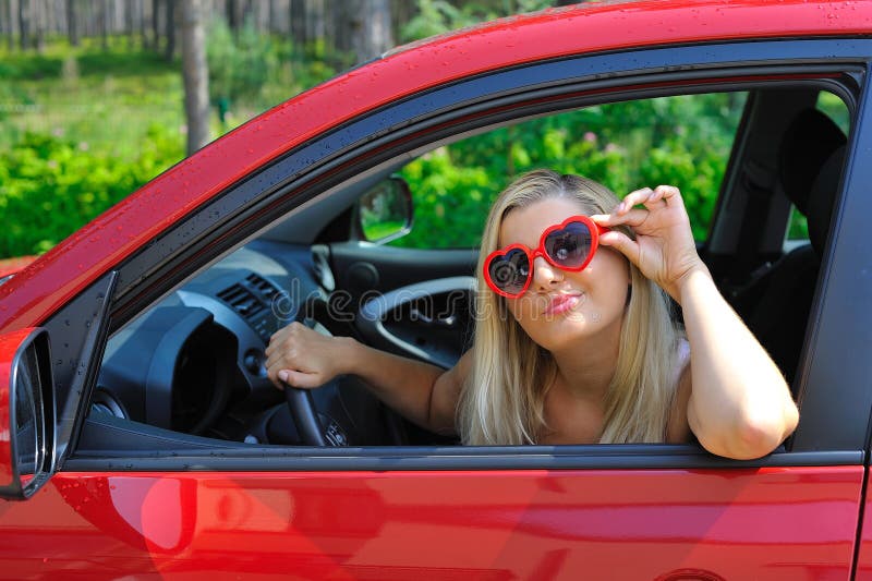 Beautiful woman in heart shaped glasses in car