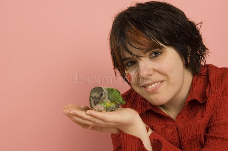 Beautiful woman holding baby parrot