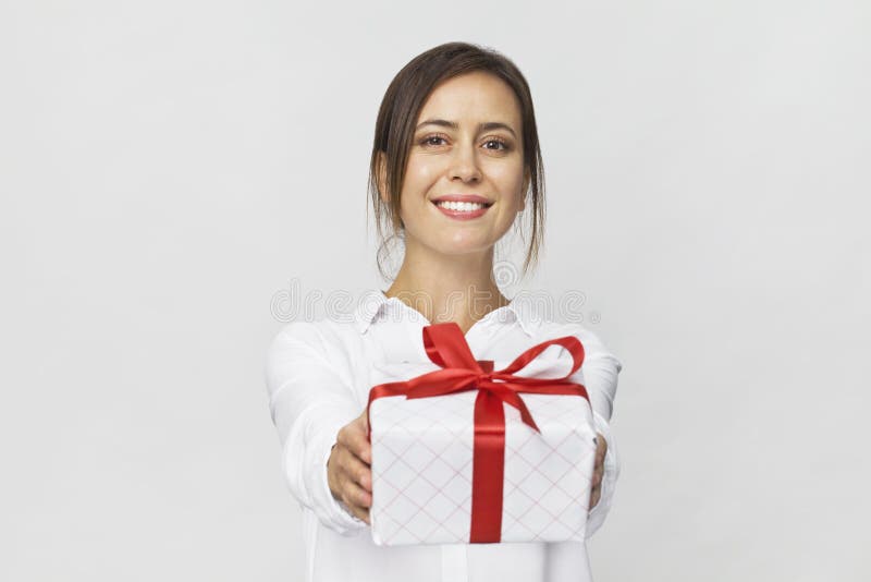 Beautiful woman holding a gift box with red ribbon. Isolated on white background