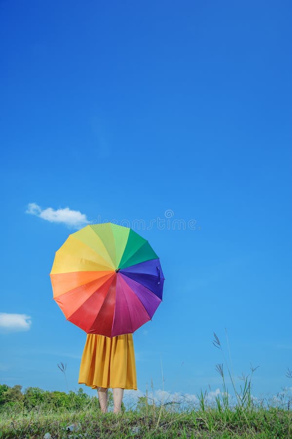 Beautiful woman holding umbrella and blue sky
