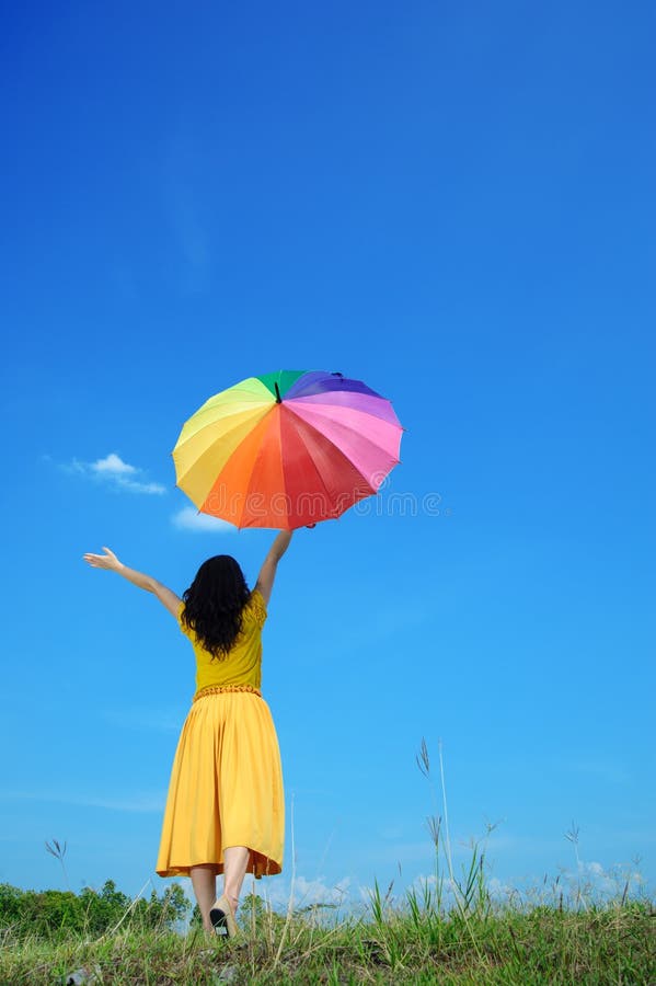 Beautiful woman holding umbrella and blue sky