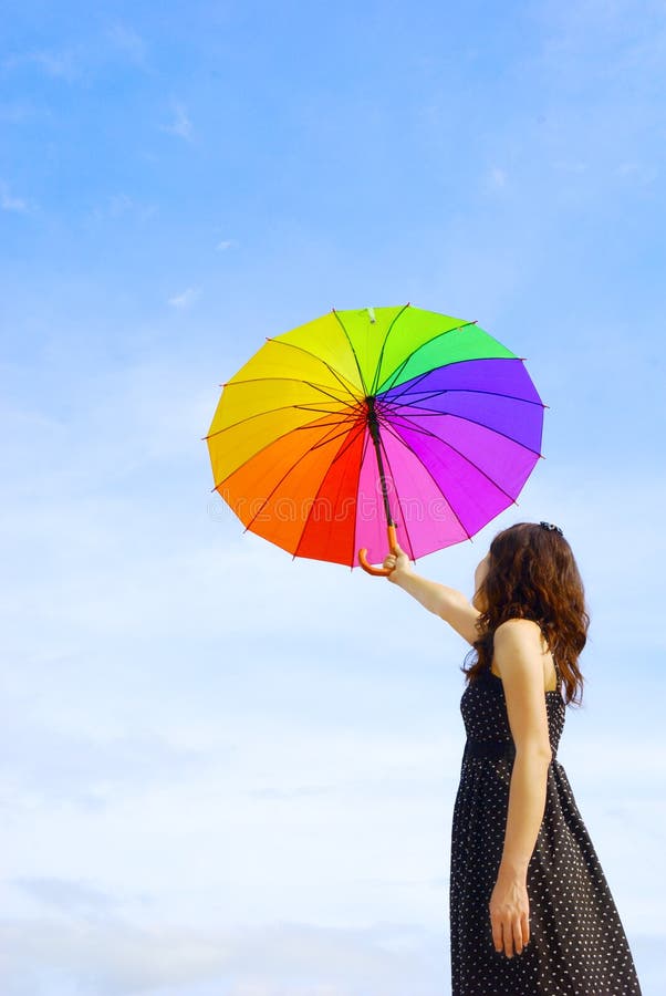 Beautiful woman holding umbrella and blue sky