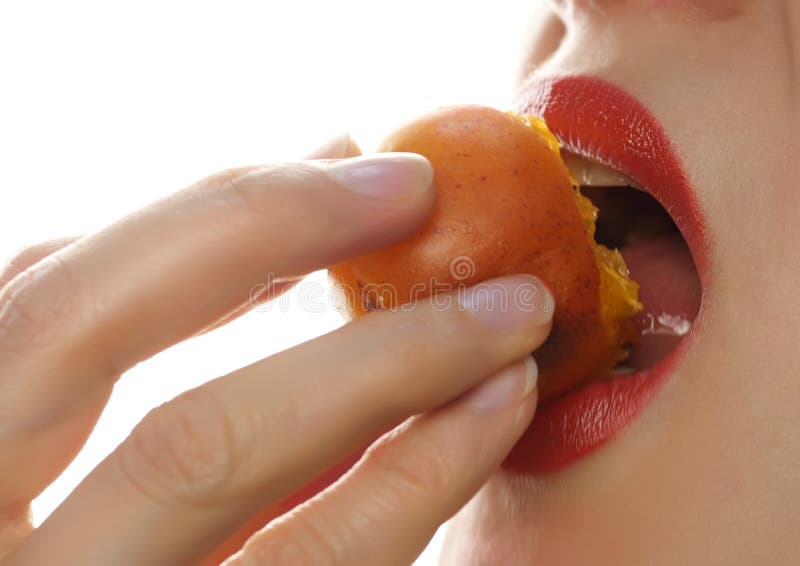 Beautiful woman licks and eating peach on a white background. close-up girl...