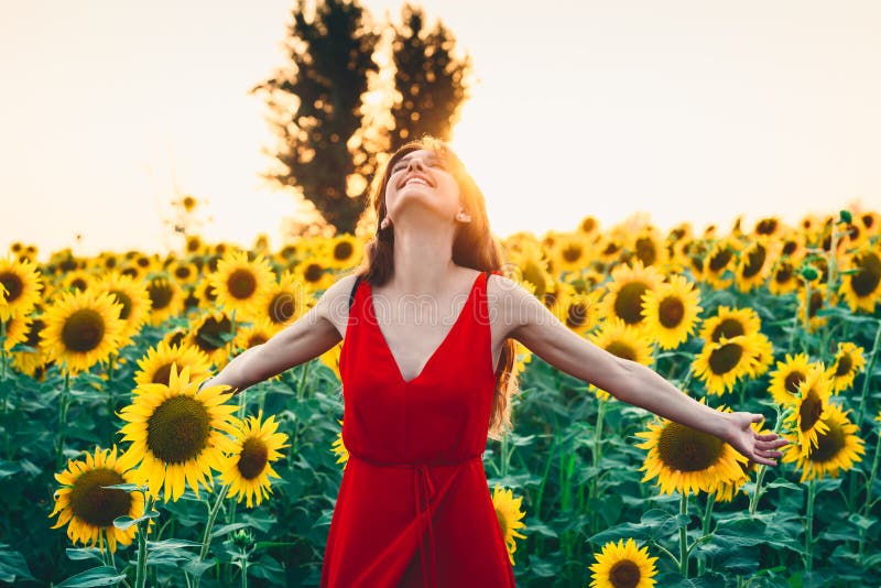 Beautiful woman with long hair in a field of sunflowers. Active, raise