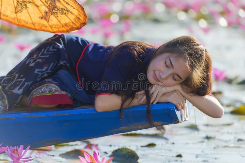 Beautiful woman lying on the boat in red lotus lake. stock image Beautiful woman lying on the boat in red lotus lake. stock image