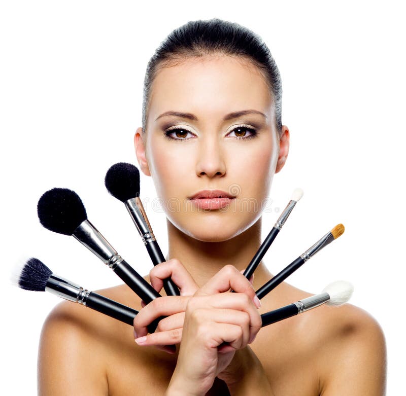 Beautiful woman with makeup brushes