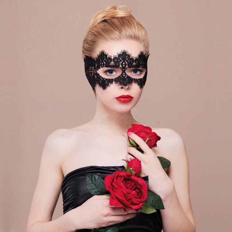 Beautiful woman in mask holding flowers