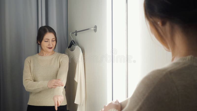 Beautiful woman measures the clothes in a fitting room