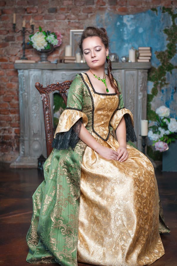 Beautiful woman in medieval dress on the chair