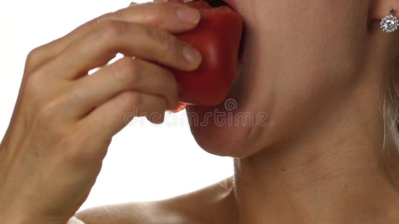 Beautiful woman mouth eating tomato. girl enjoying tasting tomato. healthy food and dieting concept. slow motion