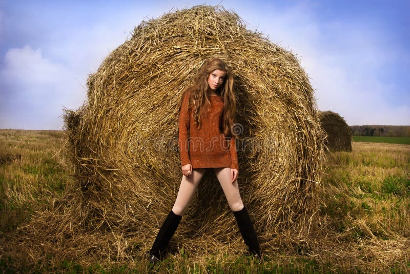 Beautiful woman near a haystack