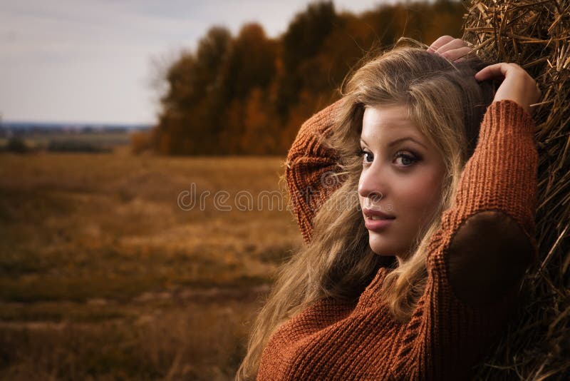 Beautiful woman near a haystack