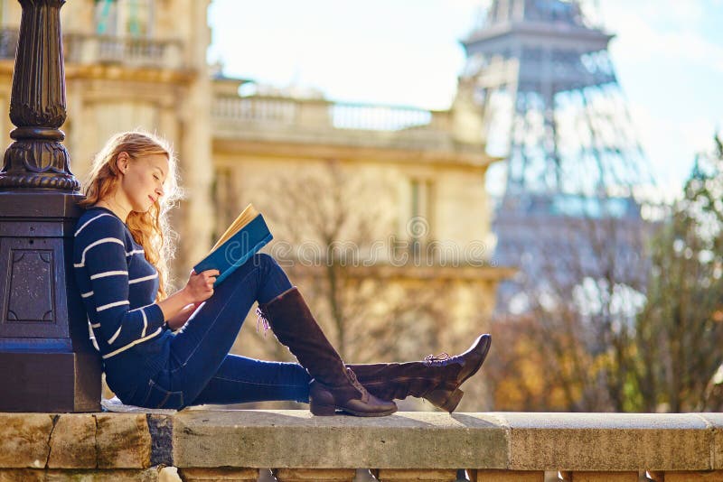 Hermoso mujer joven en París, lectura un libro.