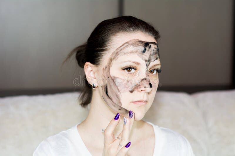 Beautiful Woman Puts on a Face Mask. the Mask is Black Stock Photo
