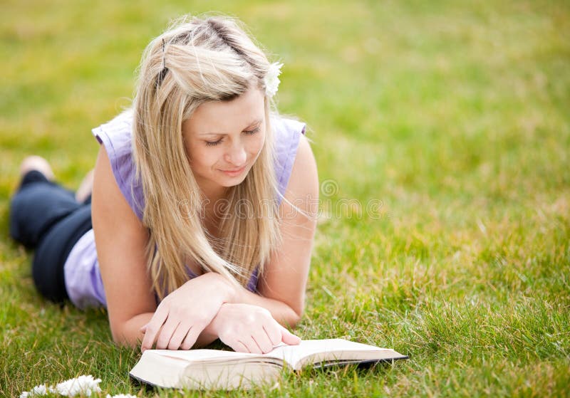 Beautiful woman reading a book in a park stock photos