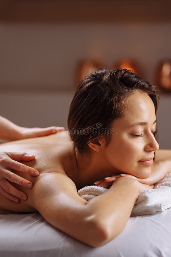Beautiful Woman Receiving a Relaxing Back Massage at Spa. Stock