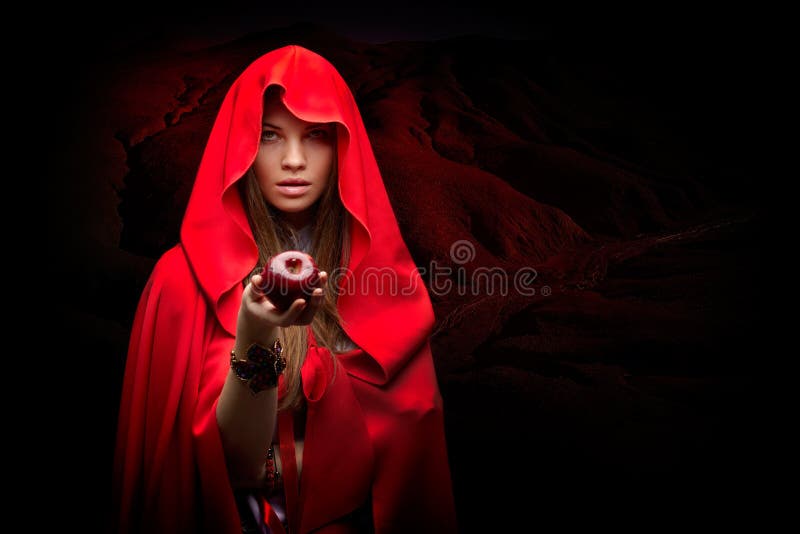 Beautiful woman with red cloak holding apple