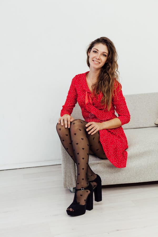 Beautiful fashionable woman in a red dress and black tights