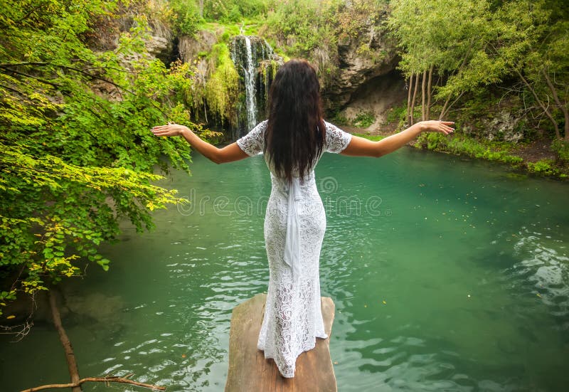 Beautiful woman relaxing in tropical waterfall