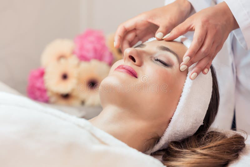 Beautiful Woman Relaxing During Rejuvenating Facial Massage Stock Image