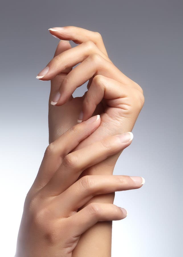 Beautiful woman`s hands on light background. Care about hand. Tender palm with natural manicure, clean skin. French nails