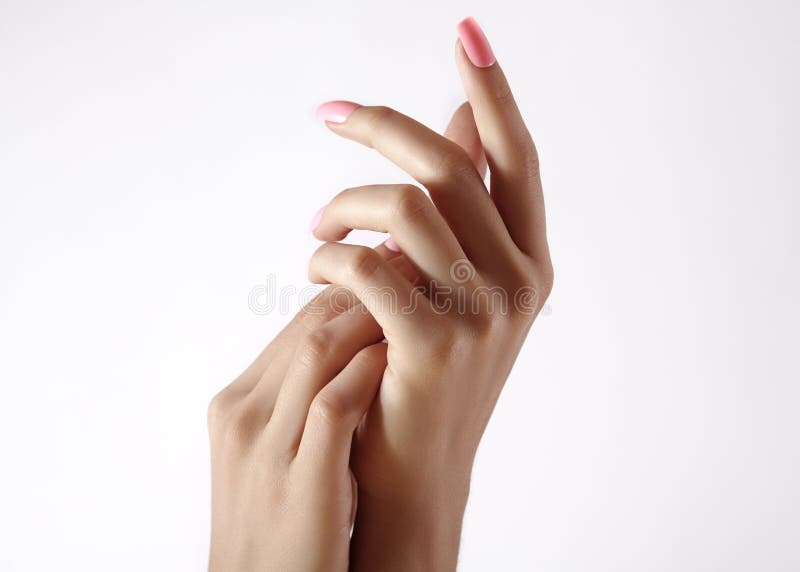Beautiful woman`s hands on light background. Care about hand. Tender palm with natural manicure, clean skin. Light pink nails