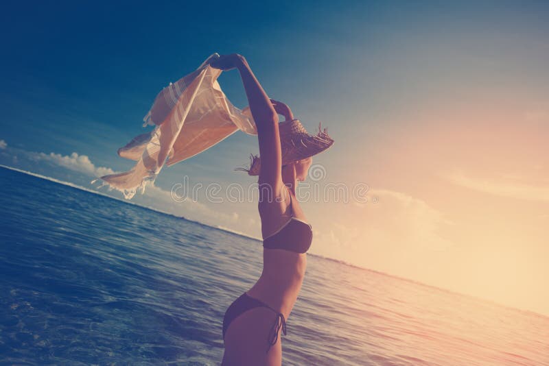 Beautiful woman with shawl in the ocean at sunset stock image Beautiful woman with shawl in the ocean at sunset stock image